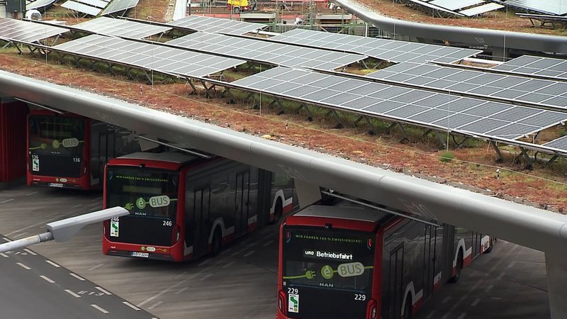 E-Busse der VAG unter einem Dach mit Solarzellen.