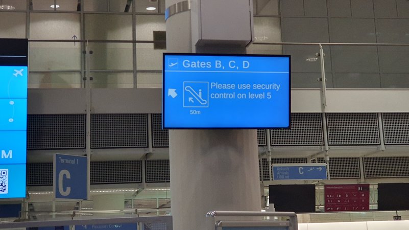 Anzeigentafel weist den Passagieren den Weg zu einer der wenigen geöffneten Sicherheitskontrollen.