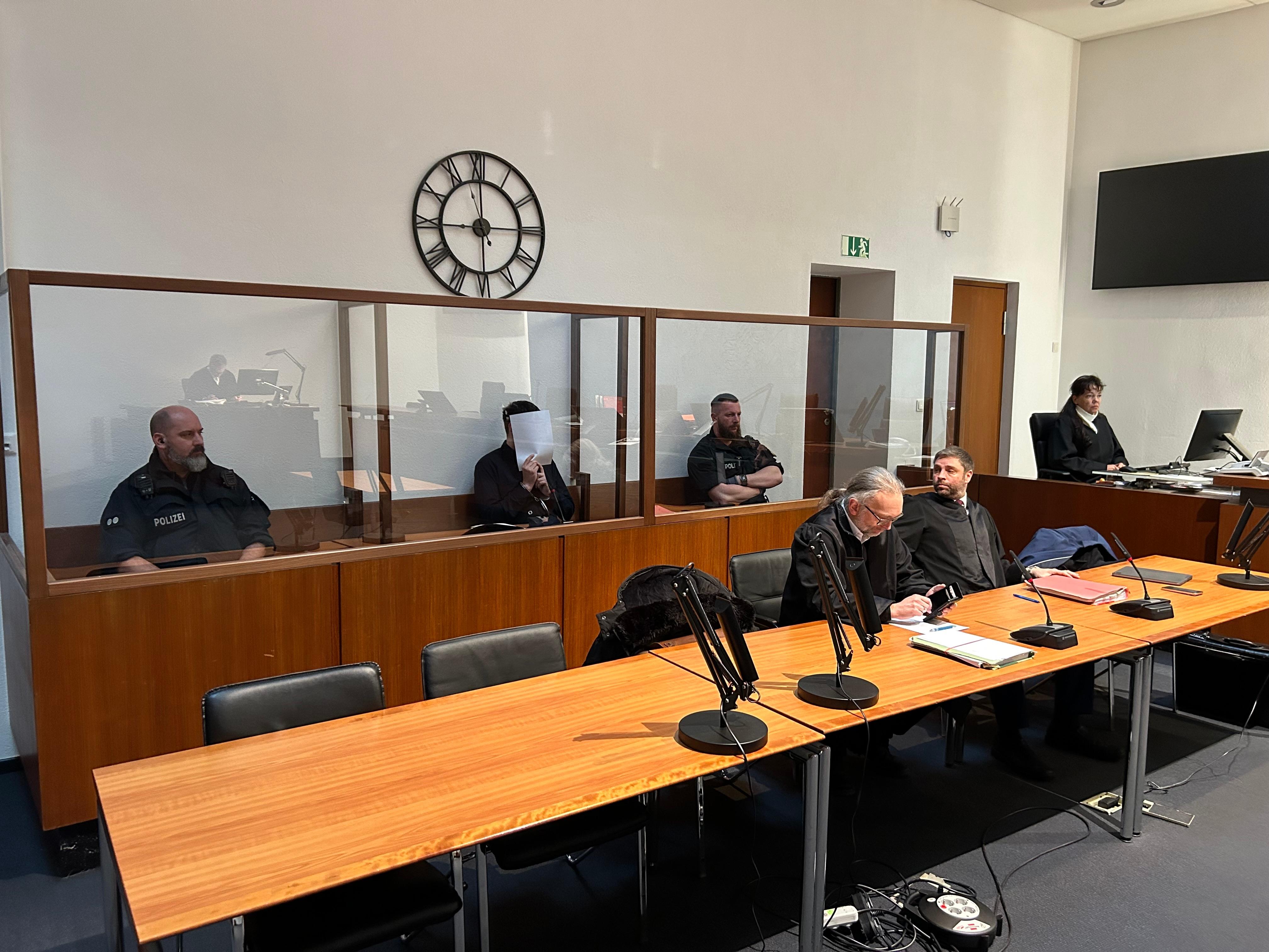 Ein Mann sitzt auf einer Anklagebank im Landgericht Hof. 