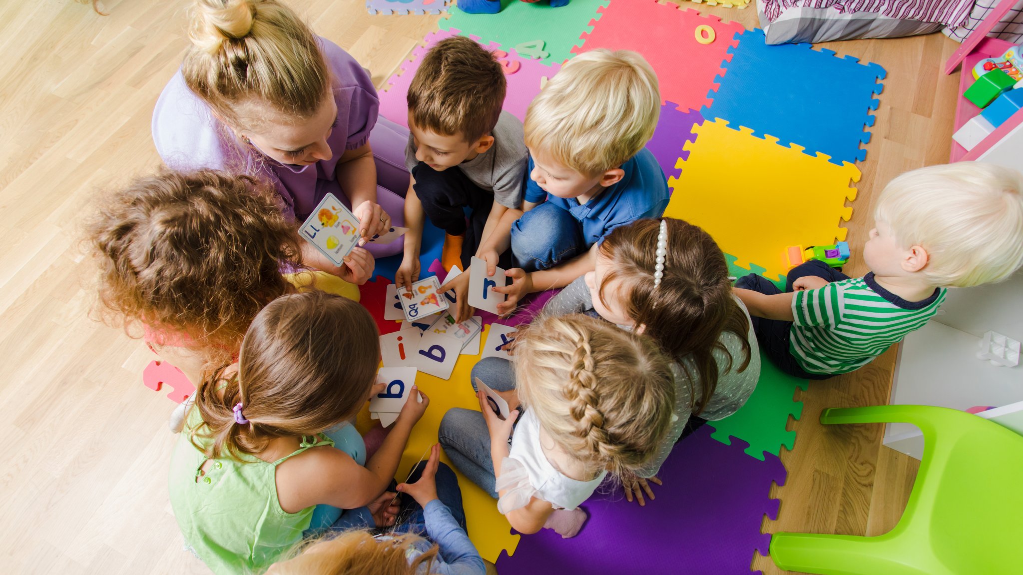Eine Erzieherin mit einer Gruppe Kinder in einer Kindertagesstätte. | Bild: stock.adobe.com/oksix Eine Erzieherin mit einer Gruppe Kinder in einer Kindertagesstätte.