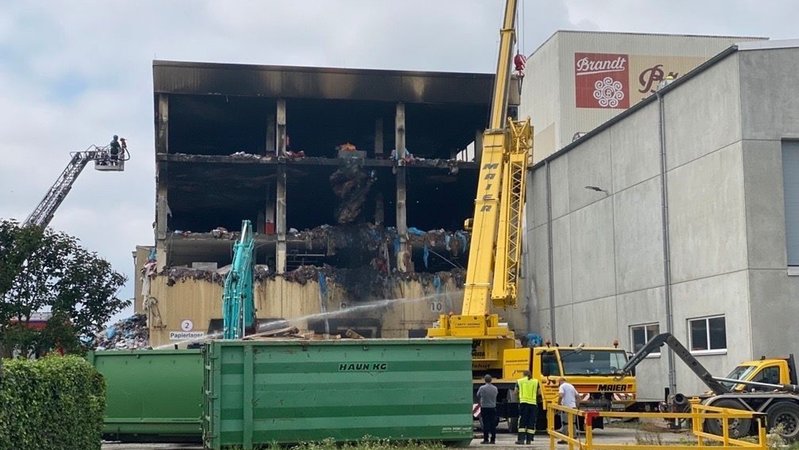 Ein ausgebranntes Lagerhaus, davor ein gelber Kran | Bild: BR/Philip Kuntschner Ein ausgebranntes Lagerhaus, davor ein gelber Kran