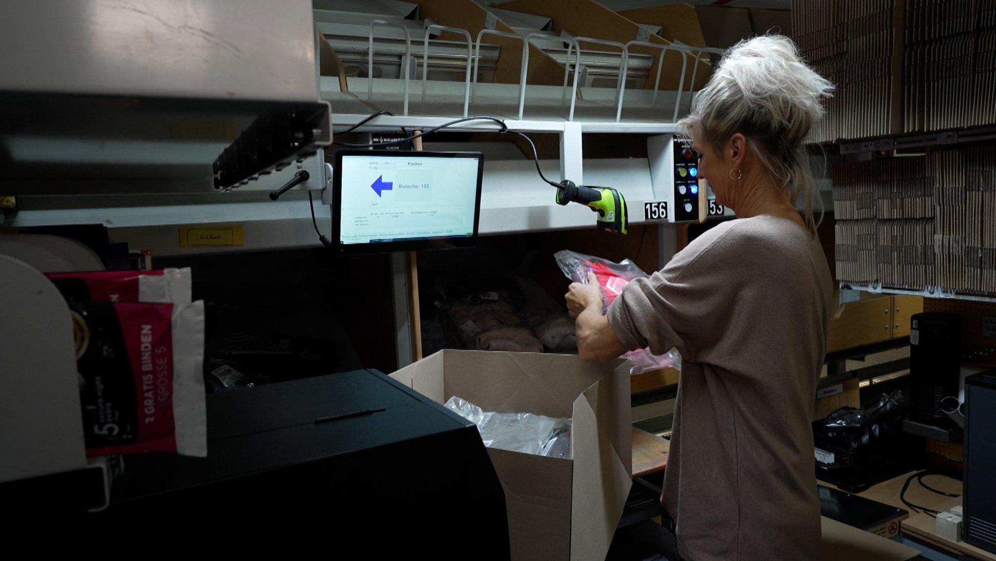 Eine Mitarbeiterin im Logistikzentrum in Altenkunstadt verpackt Pakete am Black Friday.