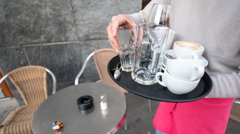 ARCHIV - 17.03.2020, Baden-Württemberg, Stuttgart: Ein Kellner räumt einen Tisch in einem Café ab (Archiv- und Symbolbild) | Bild: dpa-Bildfunk/Sebastian Gollnow ARCHIV - 17.03.2020, Baden-Württemberg, Stuttgart: Ein Kellner räumt einen Tisch in einem Café ab (Archiv- und Symbolbild)