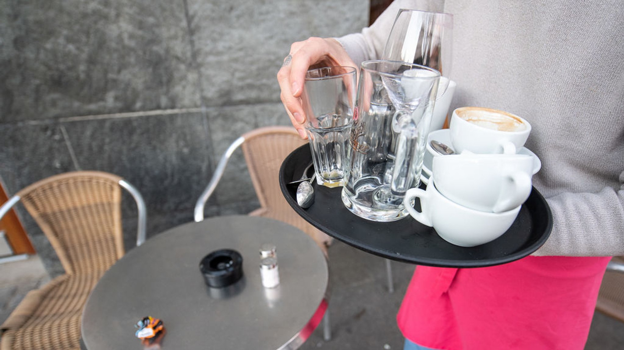 ARCHIV - 17.03.2020, Baden-Württemberg, Stuttgart: Ein Kellner räumt einen Tisch in einem Café ab (Archiv- und Symbolbild)