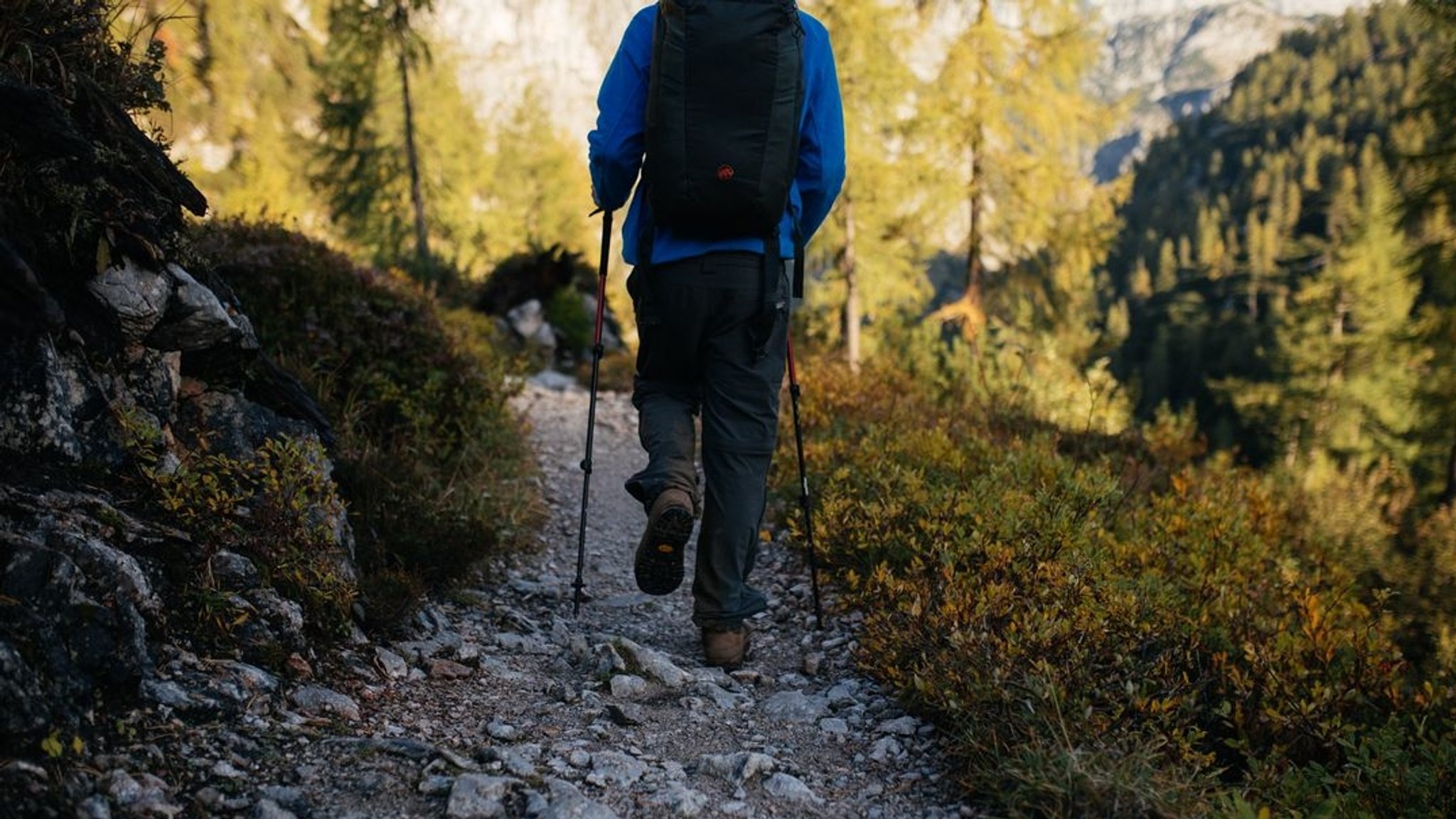 Ein Mann wandert auf einem Weg in den Bergen.