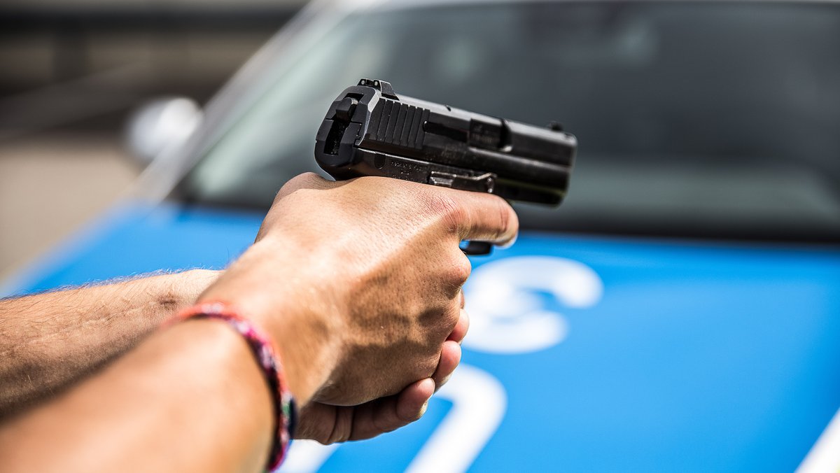Polizist hält eine Dienstpistole im Anschlag (Symbolbild)