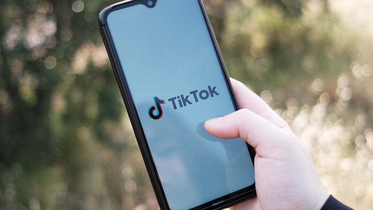 Das TikTok-Logo auf einem Smartphone-Display, gehalten von einer Hand