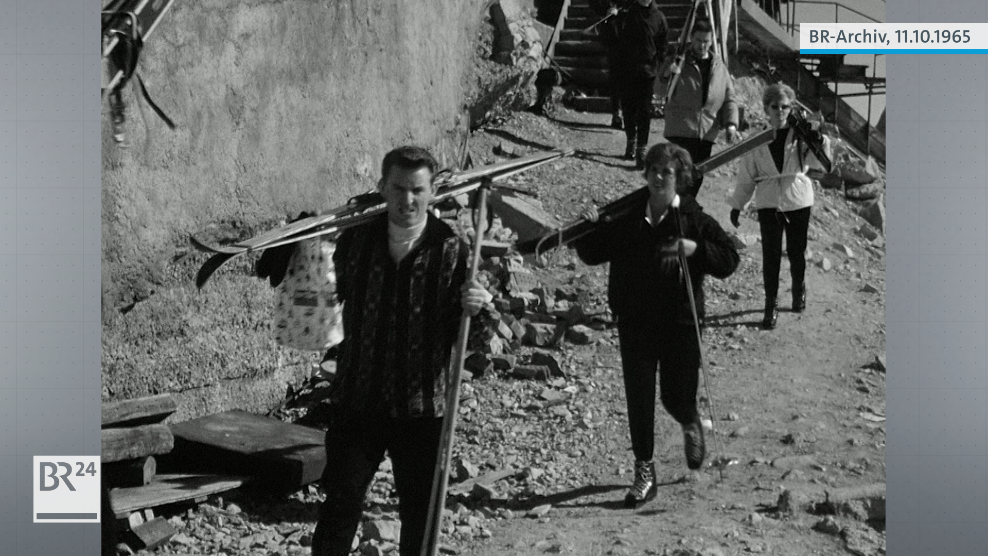 Menschen mit Skiern auf der Schulter auf dem Weg zur Piste