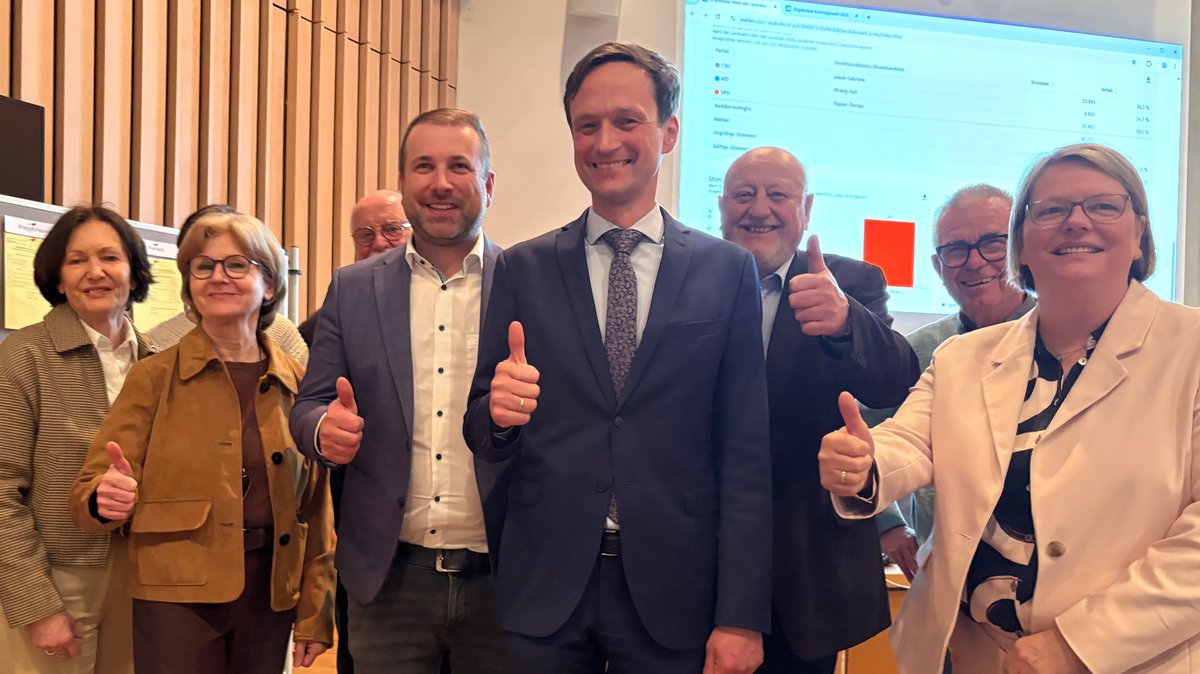 Große Freude bei Landrat Florian Töpper (vierter von links): Er bleibt im Landkreis Schweinfurt im Amt. Er ist auf dem Foto zusammen mit mehreren Personen zu sehen, die alle den Daumen nach oben zeigen.
