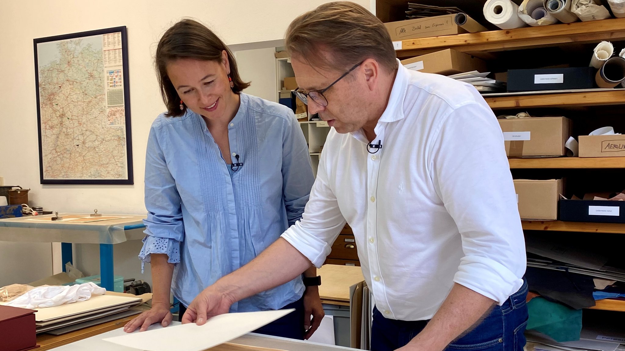 Eine Frau und ein Mann schauen sich ein Papier an.