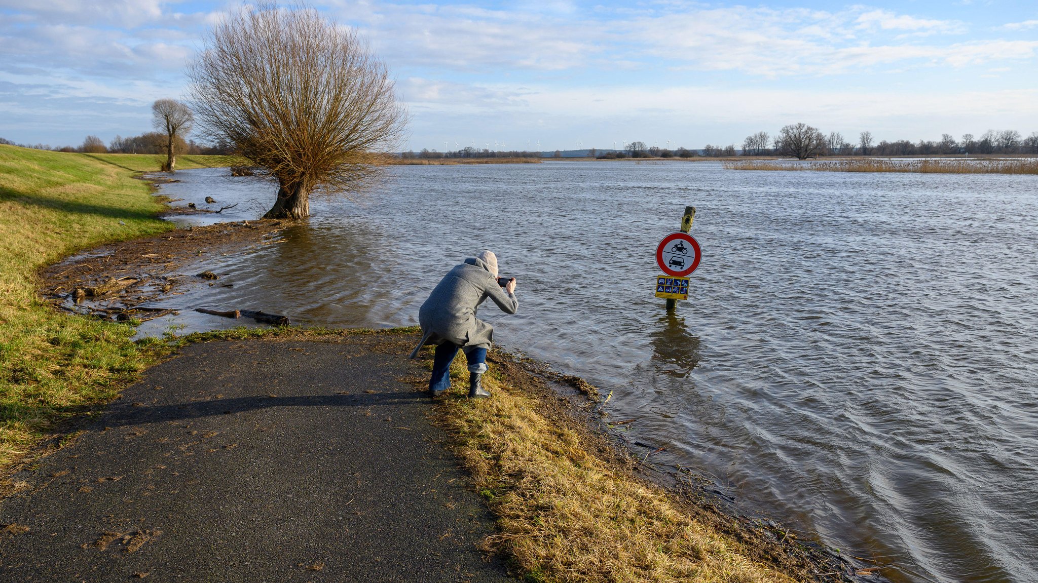 Eine Frau fotografiert im Überschwemmungsgebiet (Symbolbild)