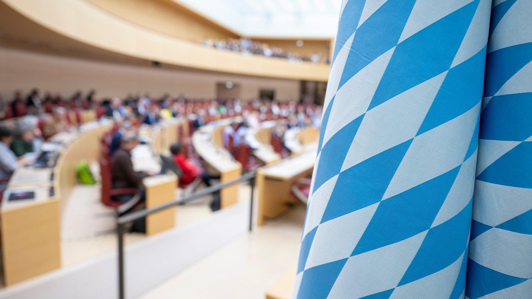 Ein Blick in das Plenum des Bayerischen Landtags. Im Vordergrund eine Bayern-Fahne.