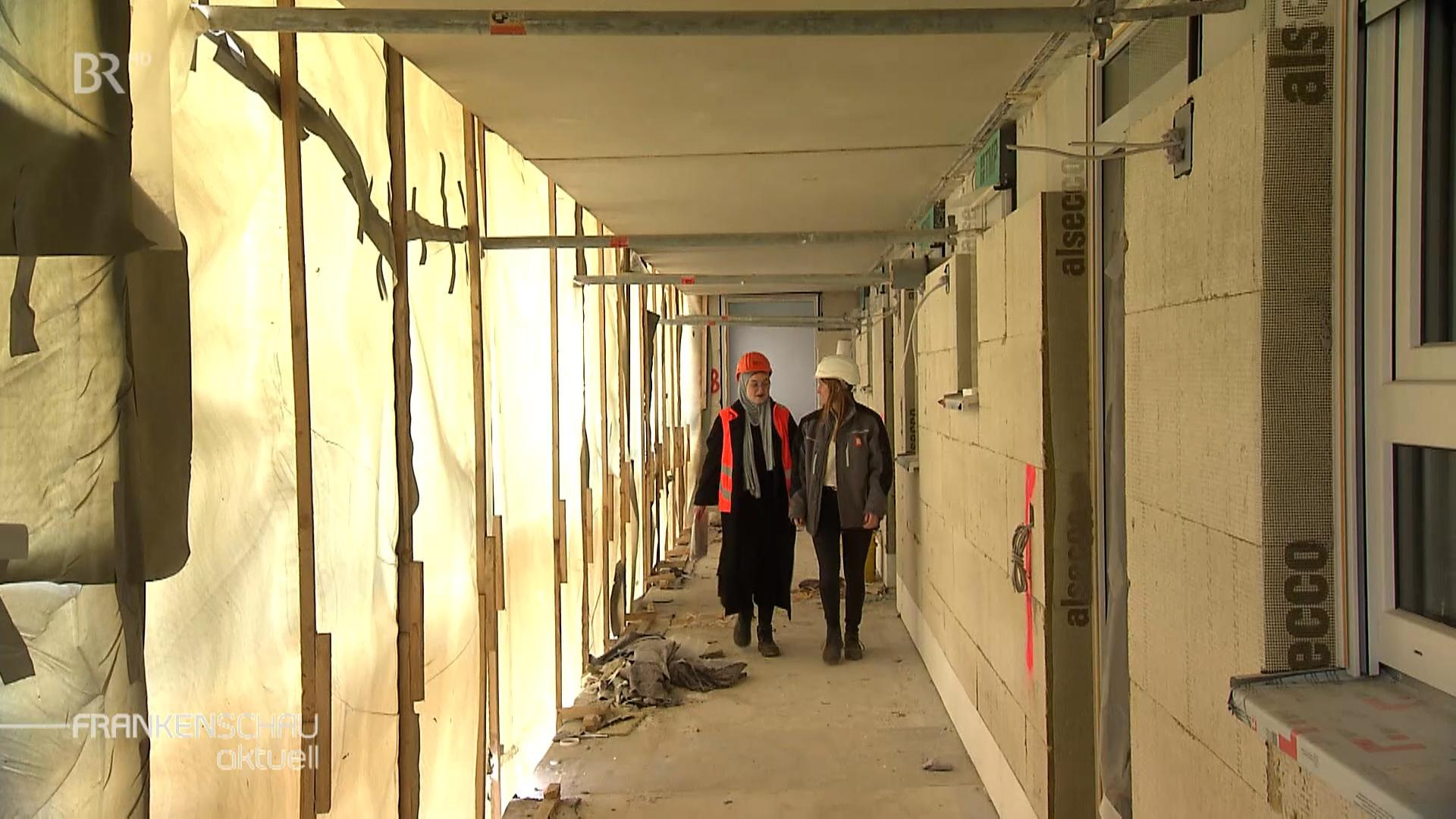 Zwei junge Frauenlaufen durch eine Baustelle