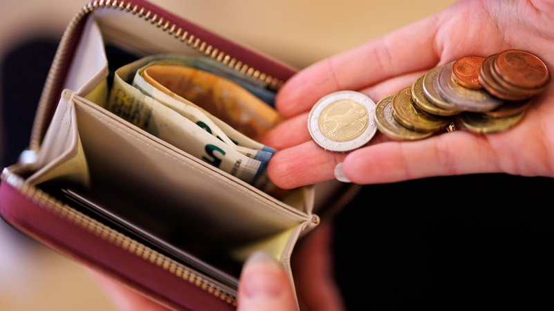 Eine Frau hält einen Geldbeutel und Münzen in der Hand. (Symbolbild) | Bild: BR Eine Frau hält einen Geldbeutel und Münzen in der Hand. (Symbolbild)