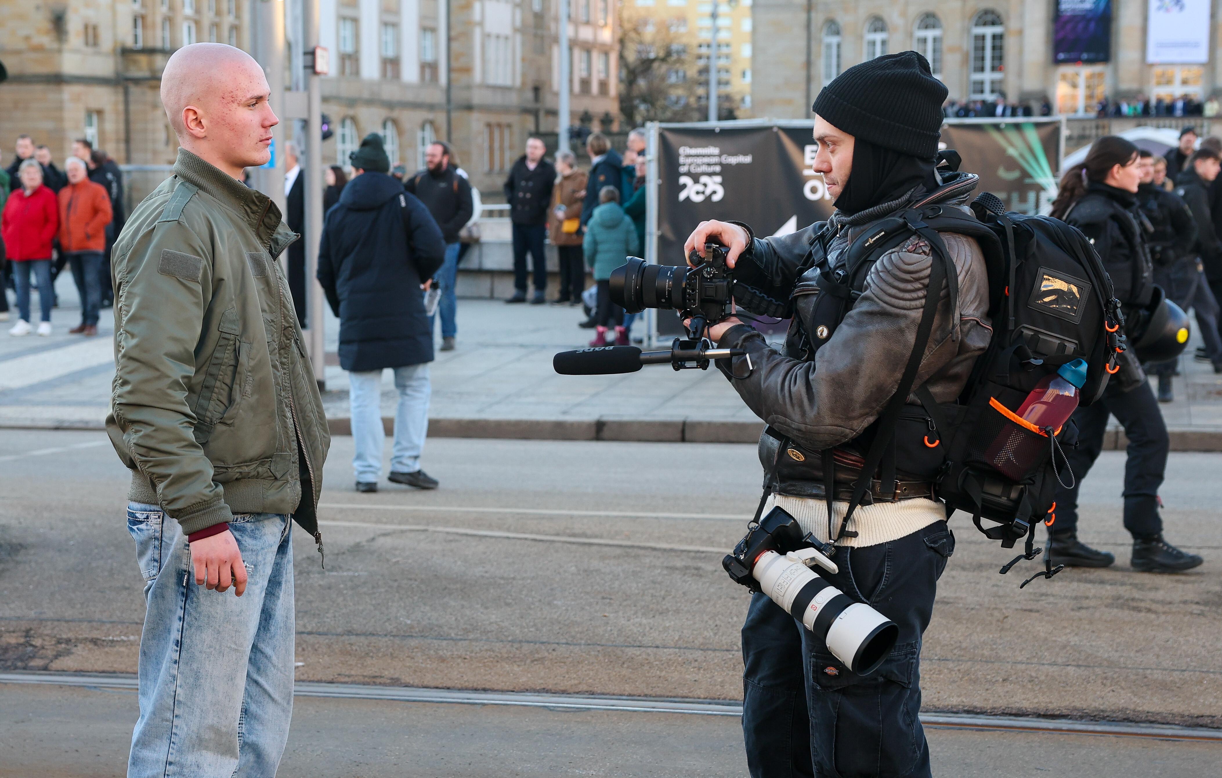 18.01.2025: Ein junger Mann steht vor einem Kameramann bei einer Demonstration der rechtsextremen Gruppierung "Freie Sachsen". 