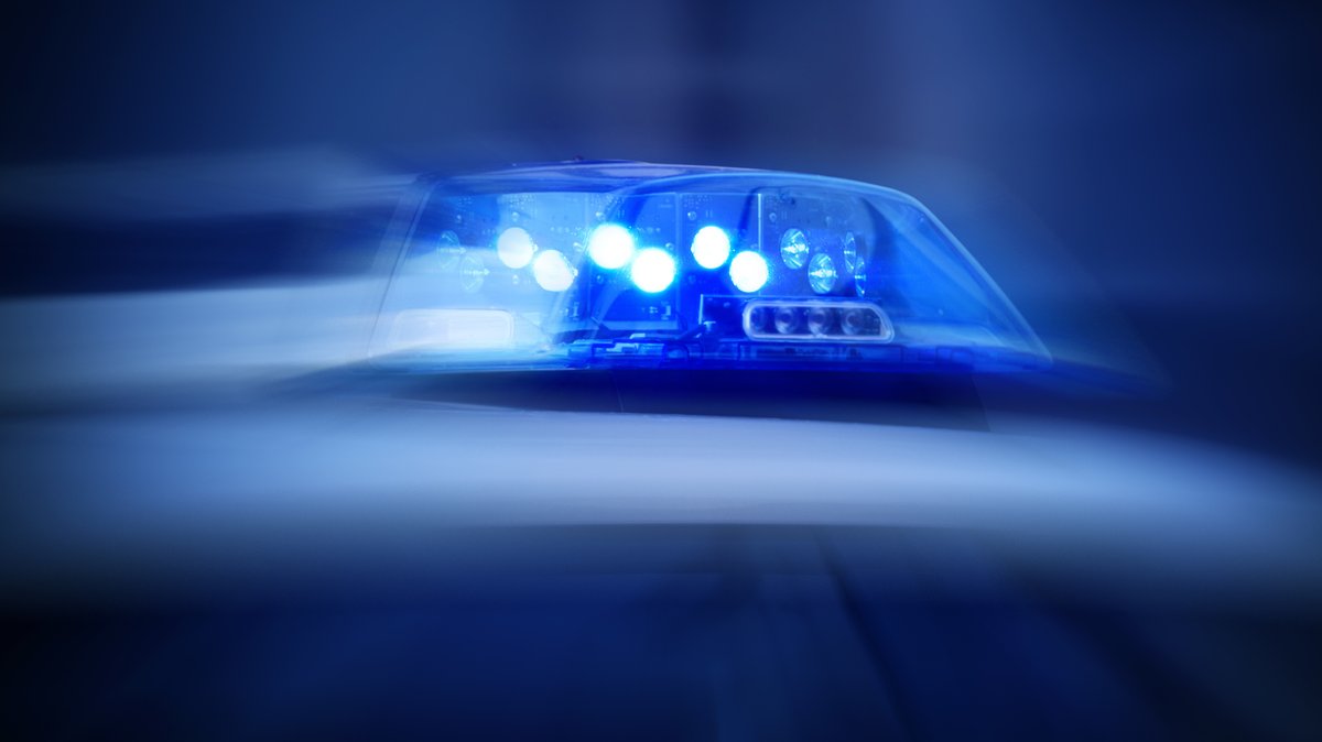 Symbolbild: Blaulicht auf dem Dach eines Polizeiautos im Dunkeln.