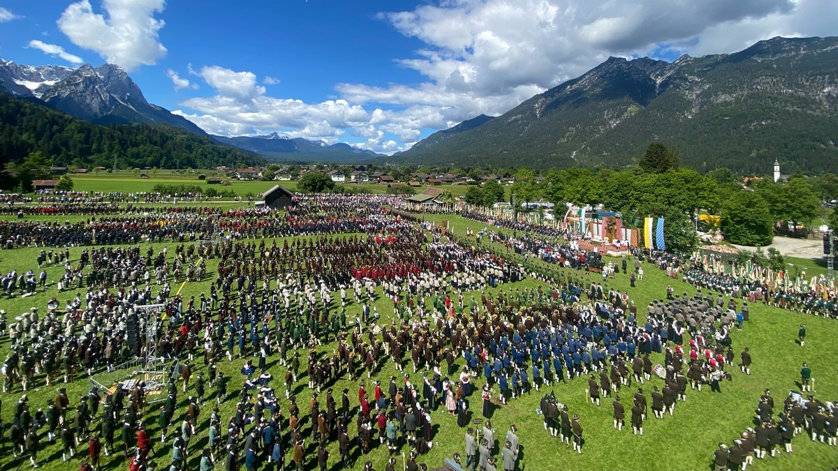Tausende Gebirgsschützen in Tracht in auf einem Feld in Garmisch-Partenkirchen