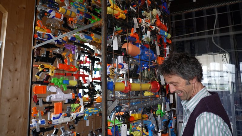 Johannes Volkmann steht an seiner Friedenssäule aus Spielzeugwaffen | Bild: BR Johannes Volkmann steht an seiner Friedenssäule aus Spielzeugwaffen