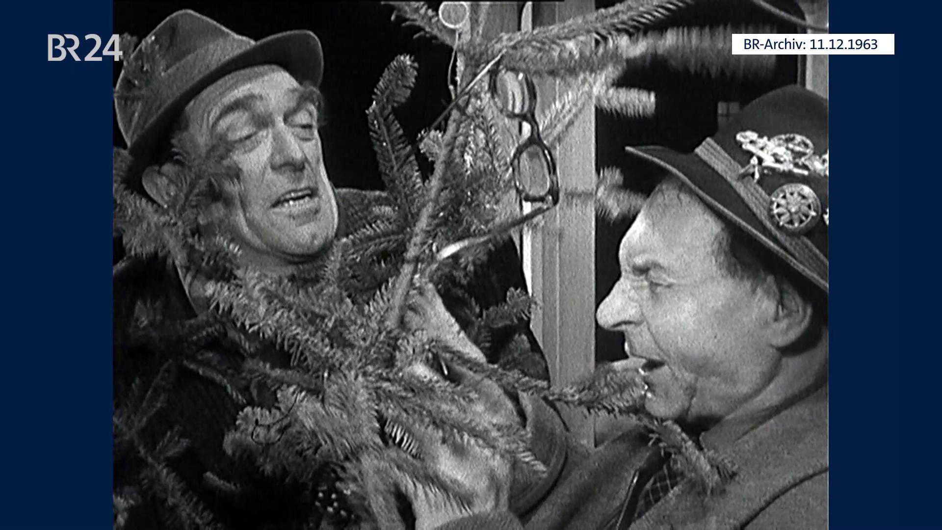 Zwei Männer mit Christbaum in der Trambahn