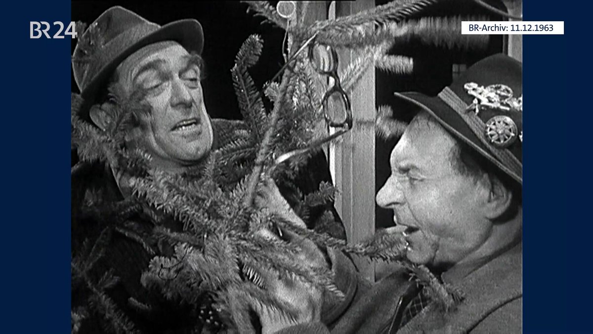 Zwei Männer mit Christbaum in der Trambahn