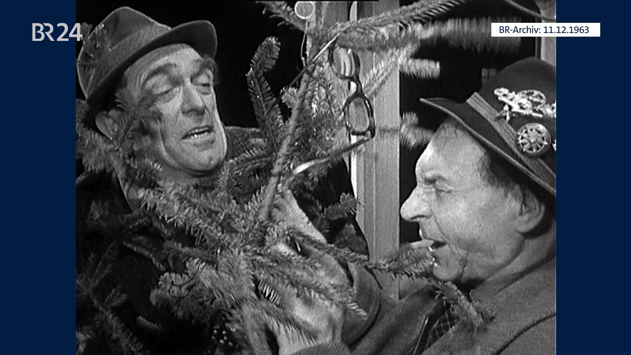 Zwei Männer mit Christbaum in der Trambahn