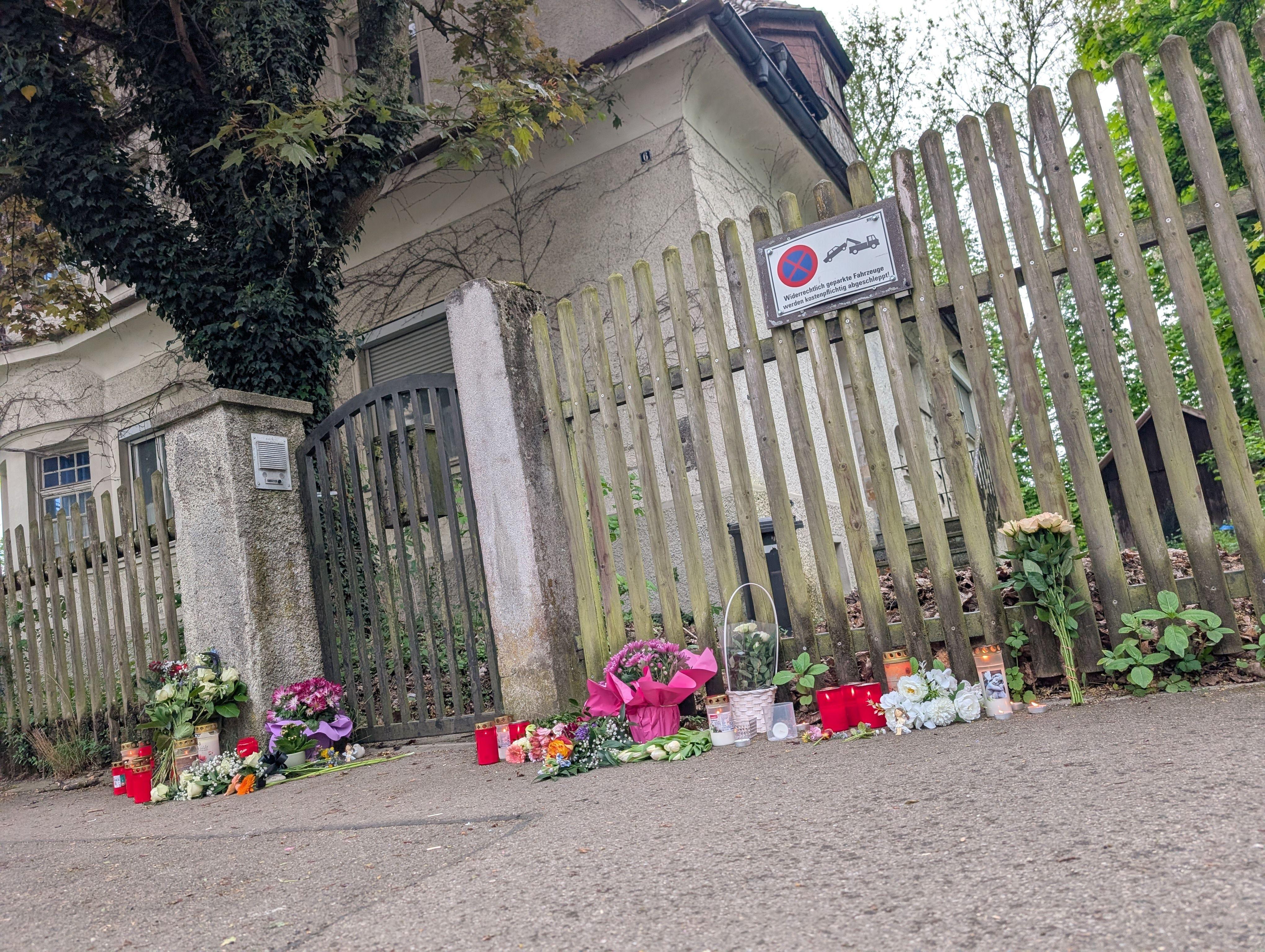 Vor dem unbewohnten Haus in der Nähe des Memminger Bahnhofs, in dem der 14-Jährige tot aufgefunden wurde, haben Menschen Blumen niedergelegt.