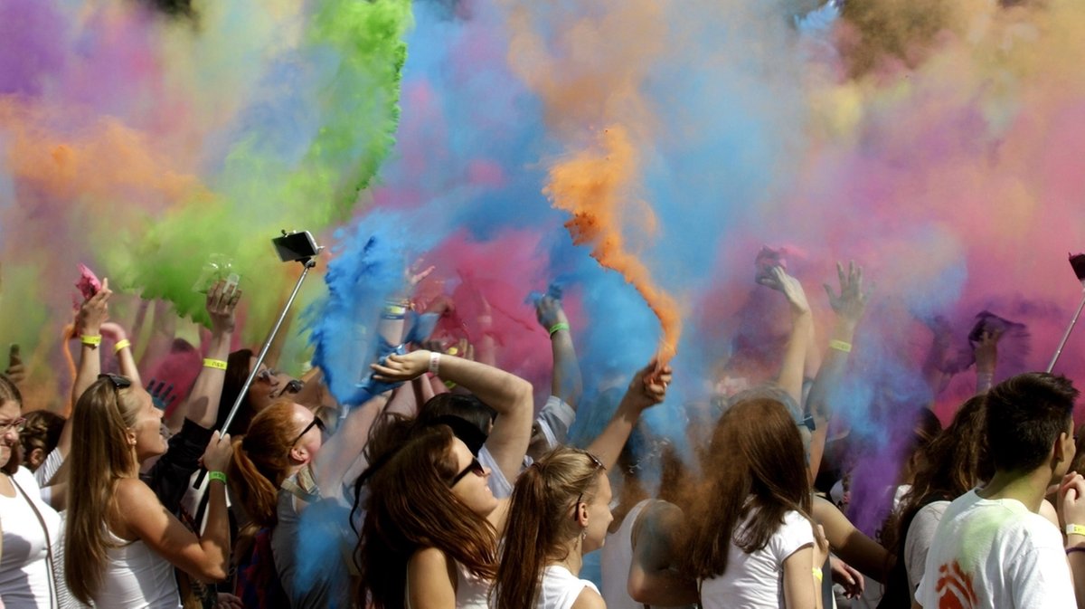 Menschen werfen anlässlich des Holi Colour Festivals 2016 in Riga, Lettland,buntes Pulver in die Luft beim Holi Colour Festival
