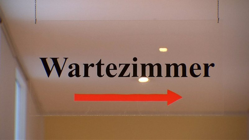 Ein Hinweisschild weist den Weg ins Wartezimmer einer Arztpraxis. | Bild: BR Ein Hinweisschild weist den Weg ins Wartezimmer einer Arztpraxis.