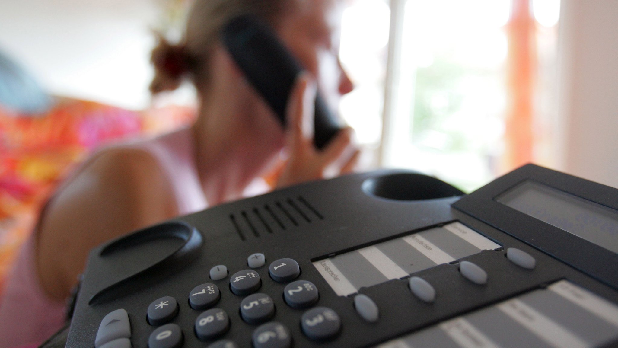 Eine Frau telefoniert im Festnetz