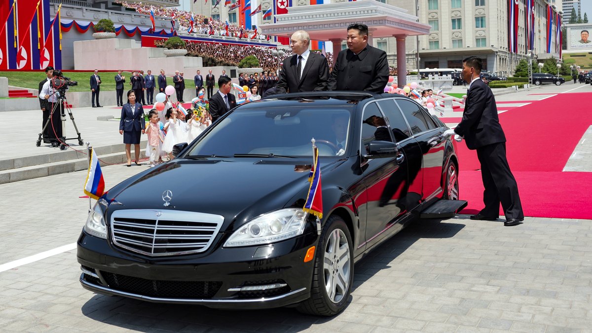 Die beiden Staatschefs in einer schwarzen Limousine vor einem roten Teppich