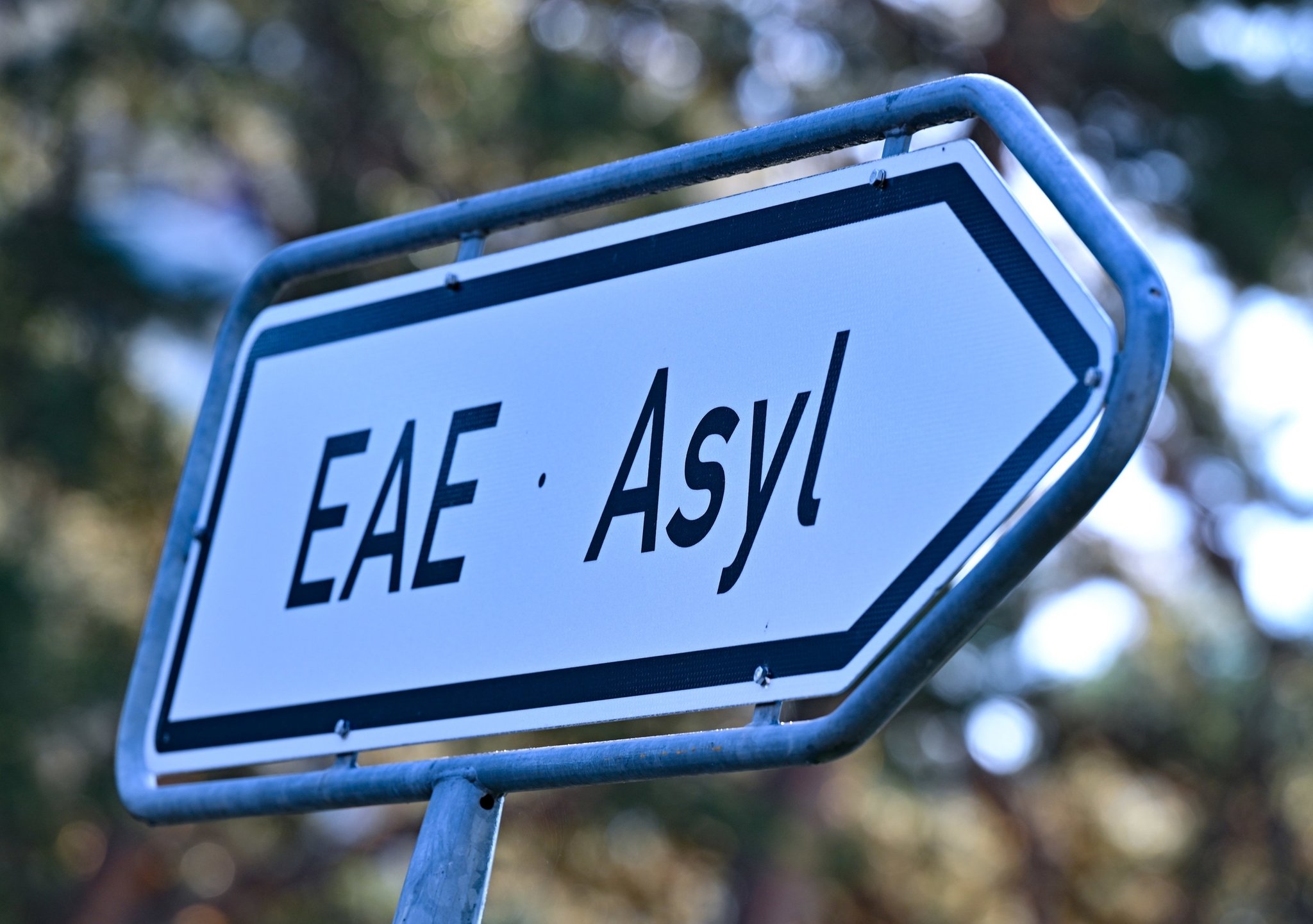 ARCHIV - 06.09.2023, Brandenburg, Eisenhüttenstadt: Ein Wegweiser mit der Abkürzung «EAE» und «Asyl» zur Erstaufnahme-Einrichtungen (EAE) des Landes Brandenburg in Eisenhüttenstadt. (Illustration zu dpa: "Gemeindebund zweifelt an schnellerem Asylverfahren und Bezahlkarte") Foto: Patrick Pleul/dpa +++ dpa-Bildfunk +++