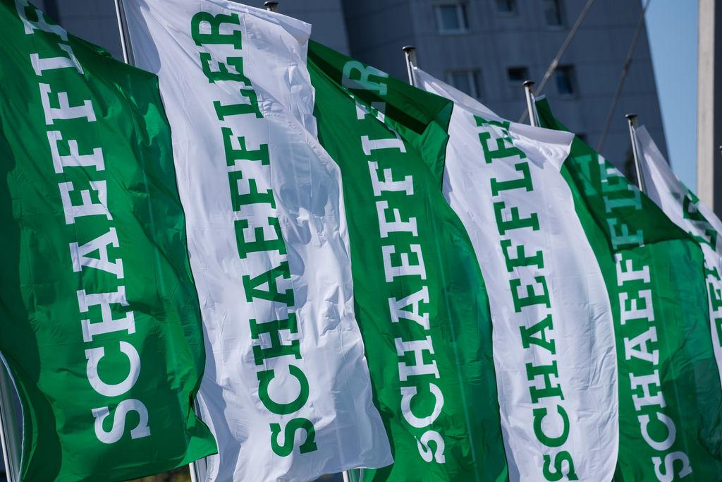 ARCHIV - 20.04.2018, Bayern, Herzogenaurach: Fahnen mit dem Schriftzug der Schaeffler AG wehen am Rande der Hauptversammlung des Unternehmens. Der Autozulieferer Schaeffler will mit der Übernahme des Antriebsspezialisten Vitesco einen Spezialisten für Elektromobilität formen. (zu dpa: «Schaeffler-Aktionäre stellen Weichen für Fusion mit Vitesco») Foto: Daniel Karmann/dpa +++ dpa-Bildfunk +++