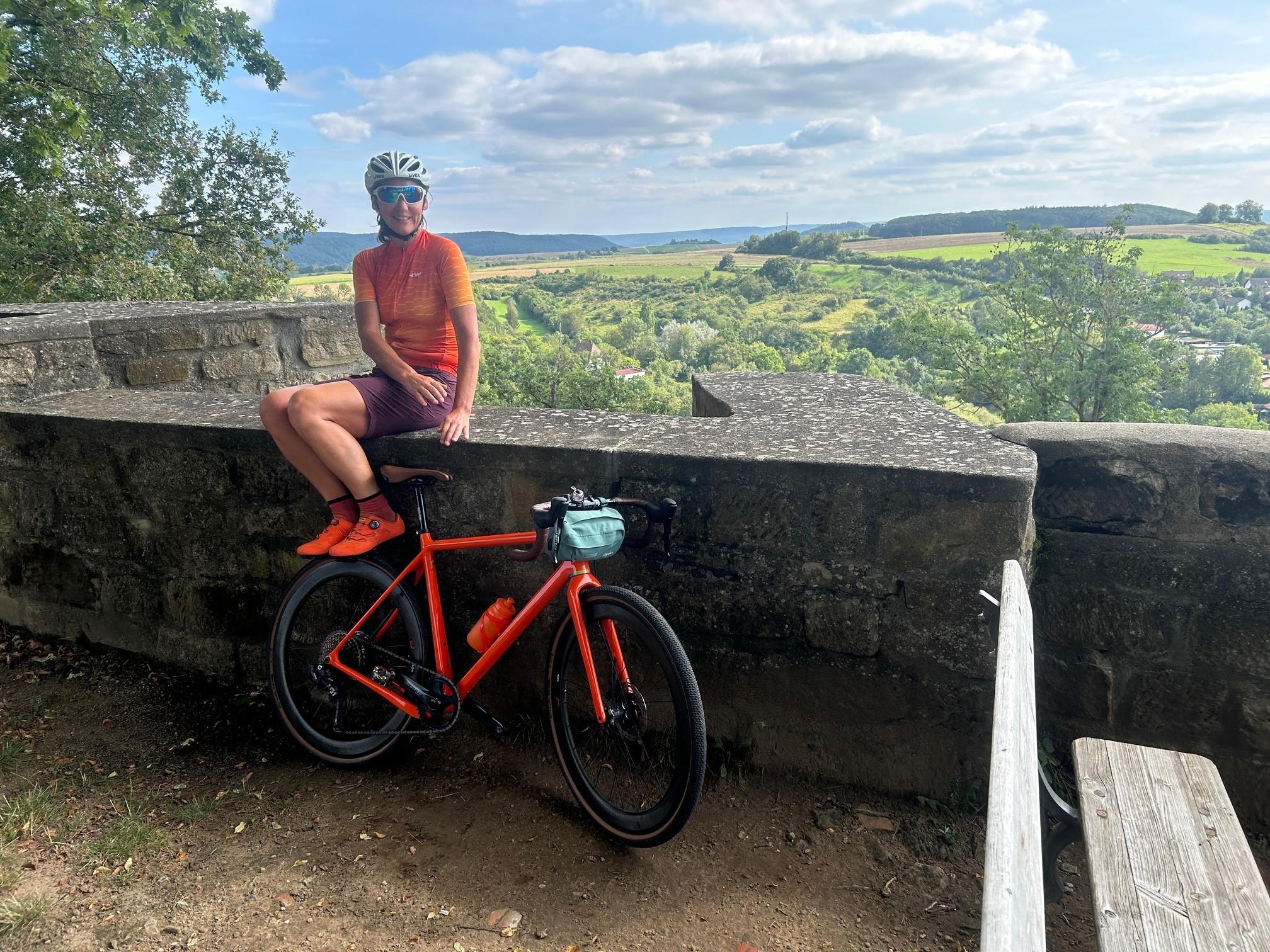 Pause mit dem Gravelbike mit Ausblick auf die Burg von Königsberg in den Haßbergen.