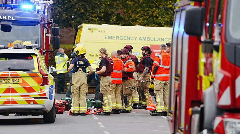 Einsatzkräfte von Polizei und Rettungsdienst stehen auf einer Straße in Manchester. | Bild: picture alliance / empics | Peter Byrne Einsatzkräfte von Polizei und Rettungsdienst stehen auf einer Straße in Manchester.