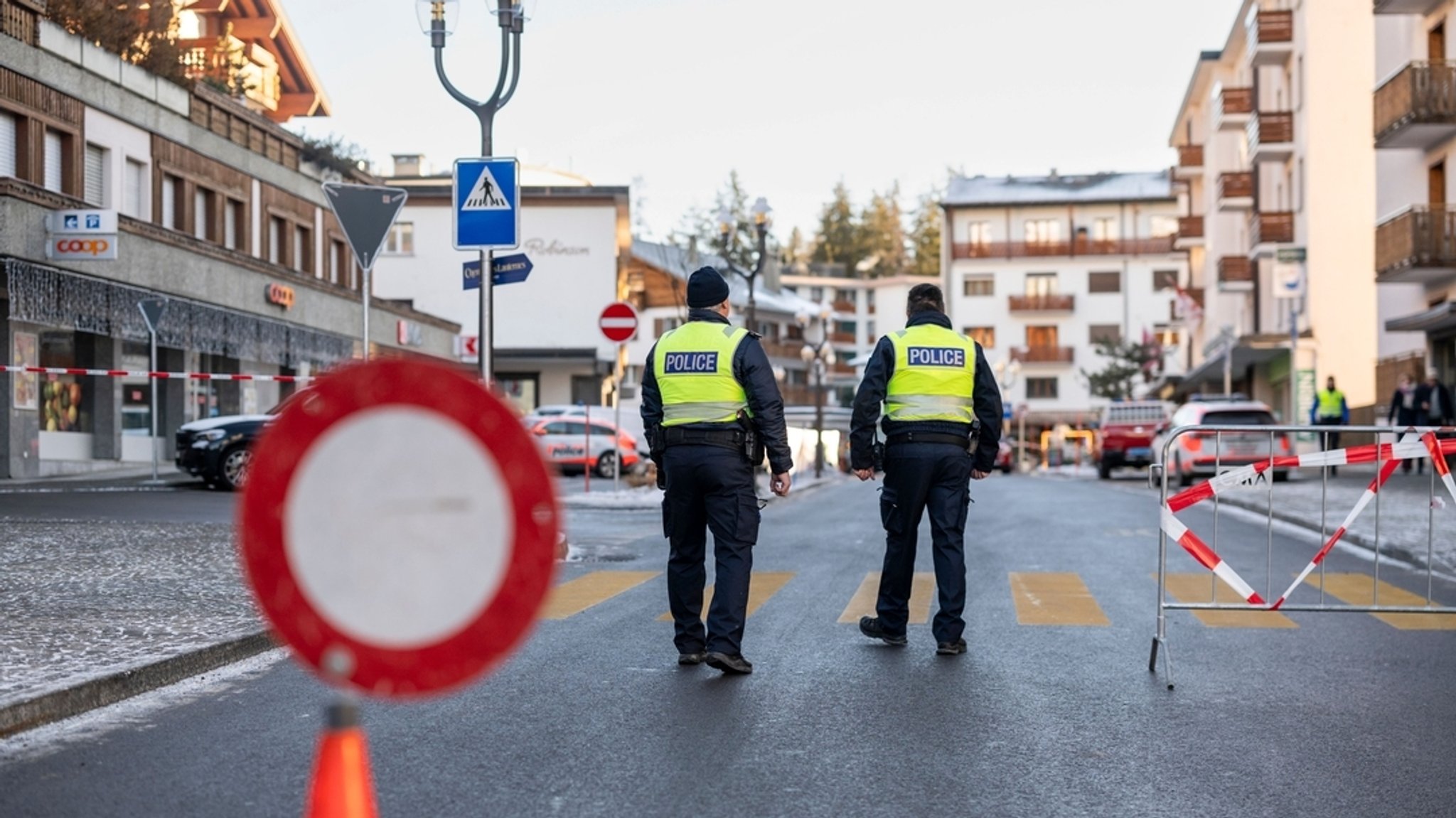 01.01.2026, Schweiz, Crans-Montana: Polizeibeamte sind in der Nähe des Bereichs zu sehen, in dem in der Bar und Lounge Le Constellation nach einer Explosion in den frühen Morgenstunden der Silvesternacht ein Feuer ausgebrochen ist. 
