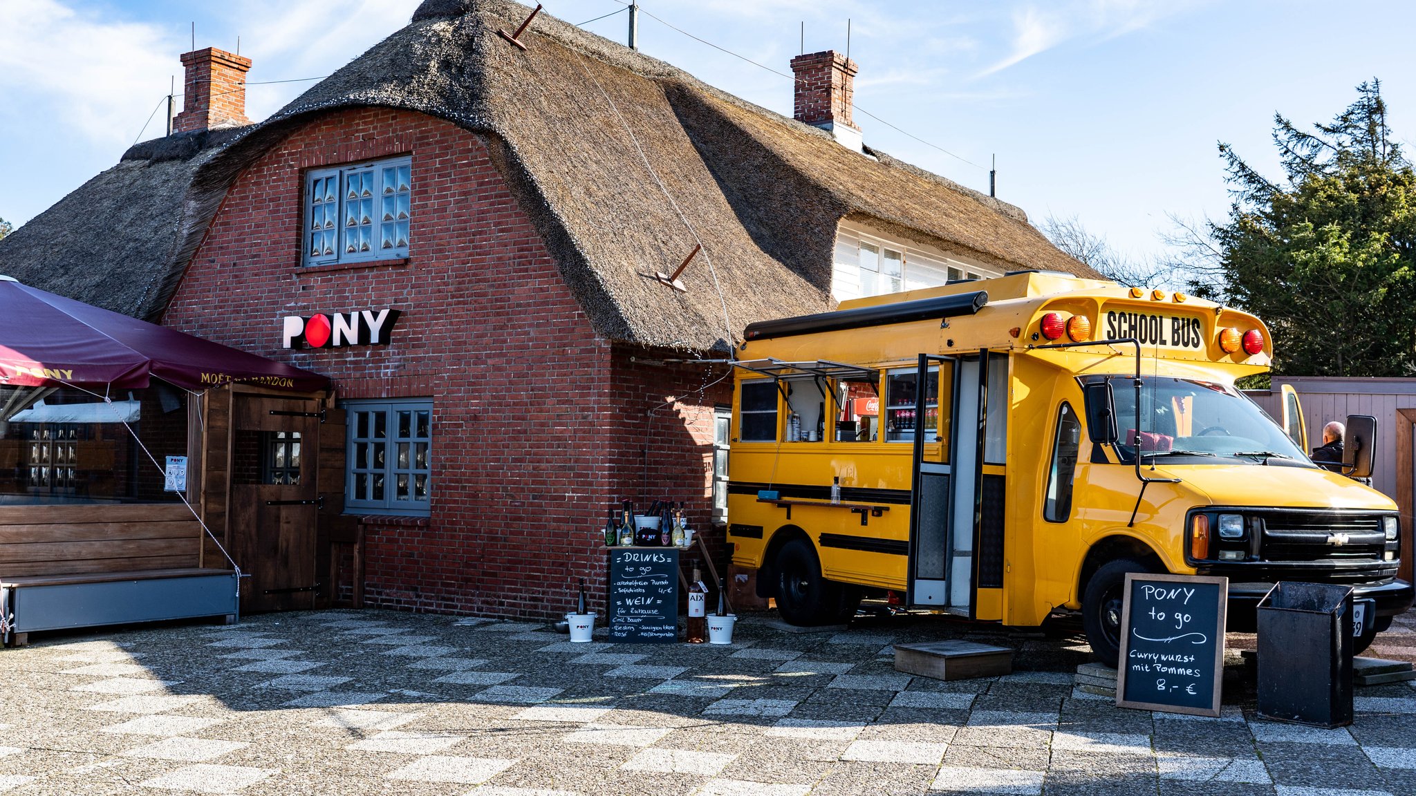 Ein alter amerikanischer Schulbus steht als Ausschank neben der Gaststätte "Pony" in der Straße Strönwai im Zentrum von Kampen.