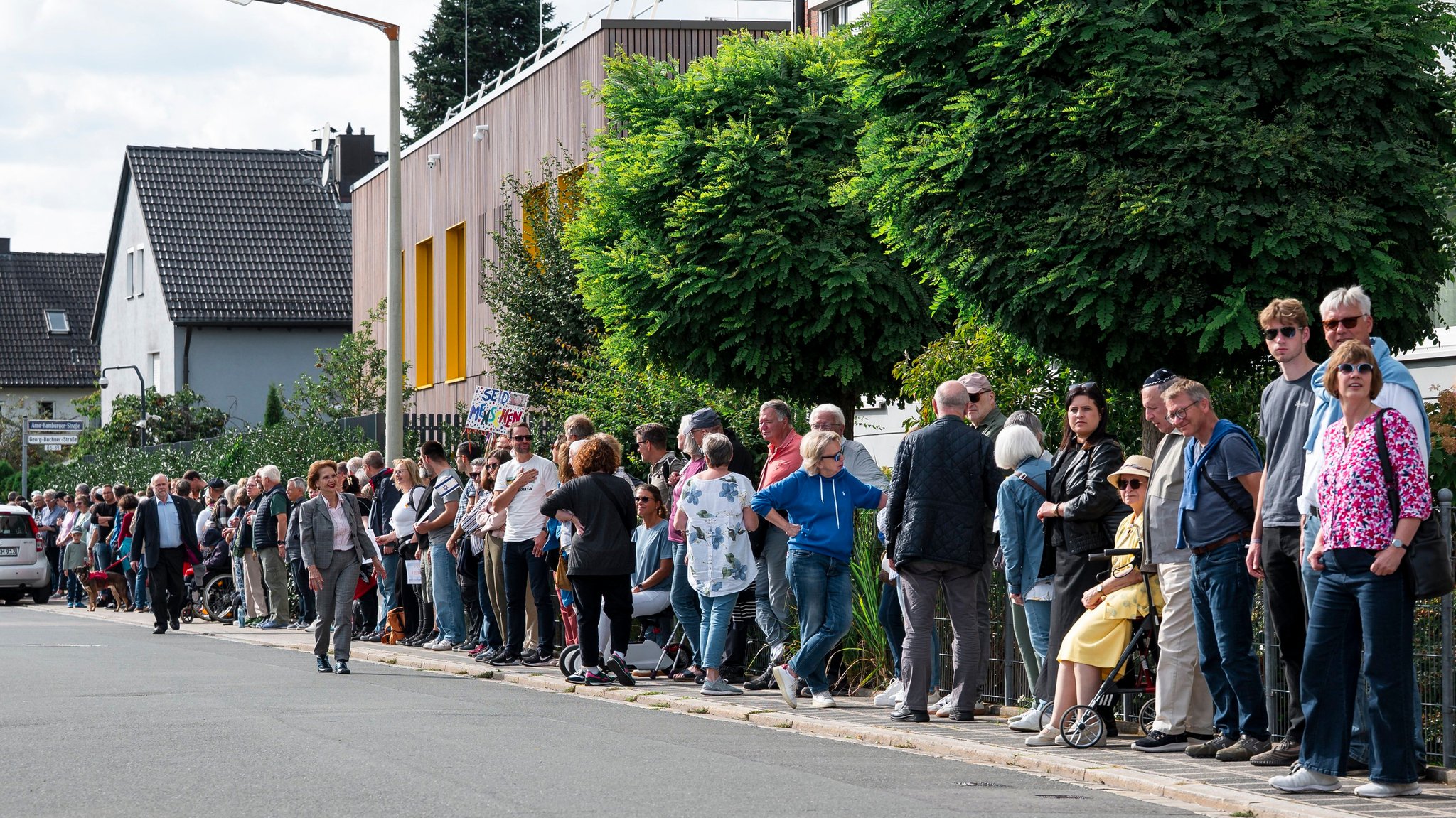 Hunderte Menschen stehen in der Arno-Hamburger-Straße in Nürnberg nebeneinander, um eine Kette um die israelitische Kultusgemeinde zu formen.