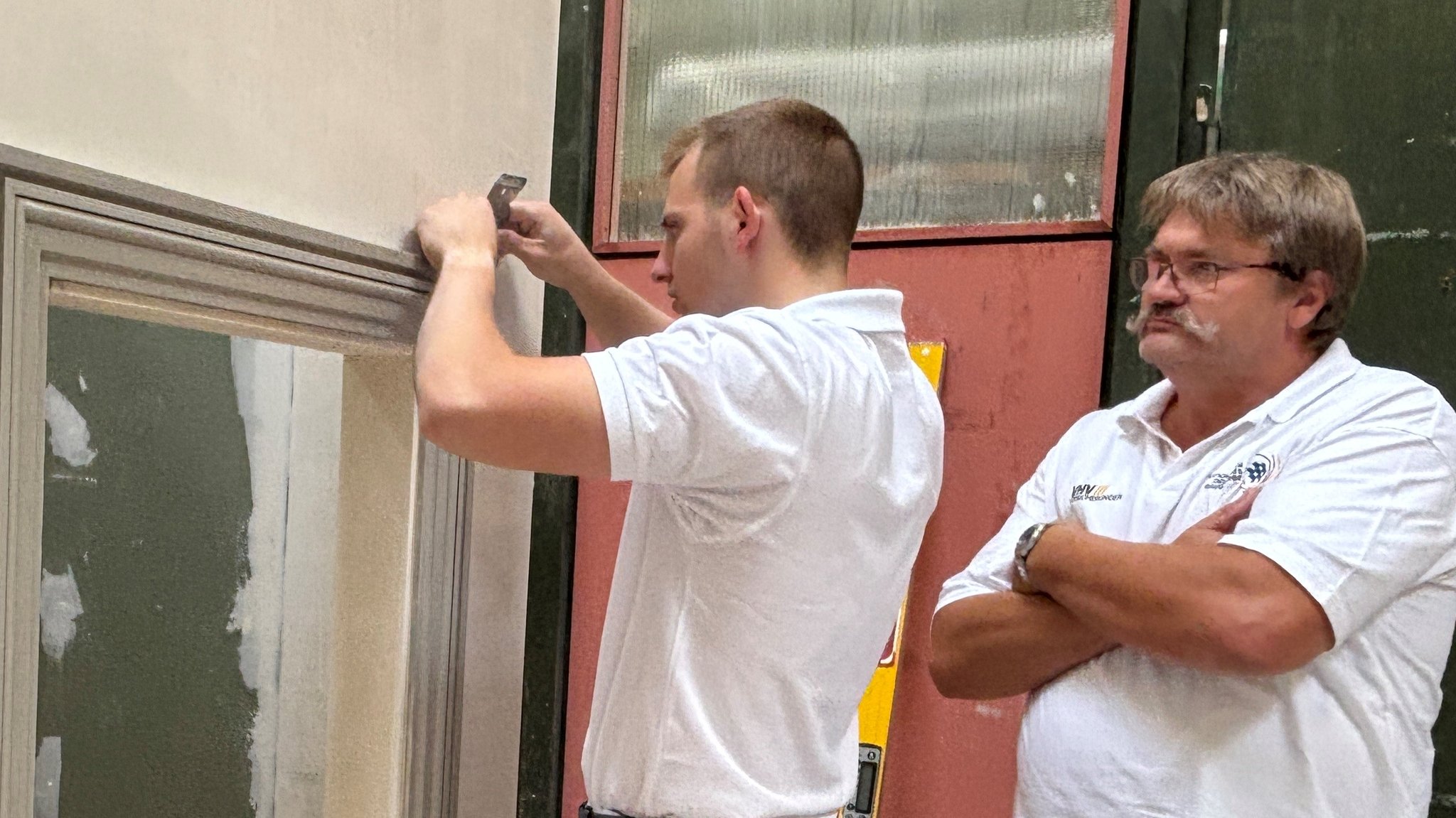 Stuckateur Franz Lehnert mit Trainer Josef Gruber bei der Feinarbeit an einem Fensterrahmen beim Training in Nördlingen.