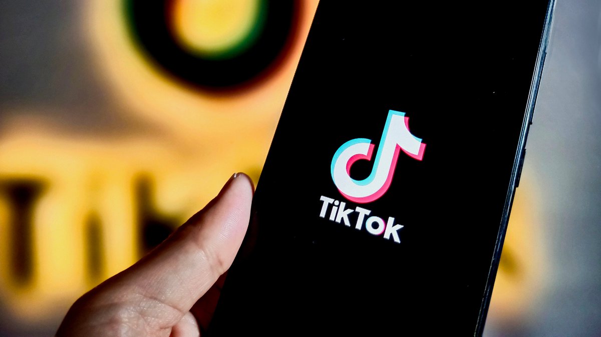 TikTok-Logo auf schwarzem Handybildschirm.