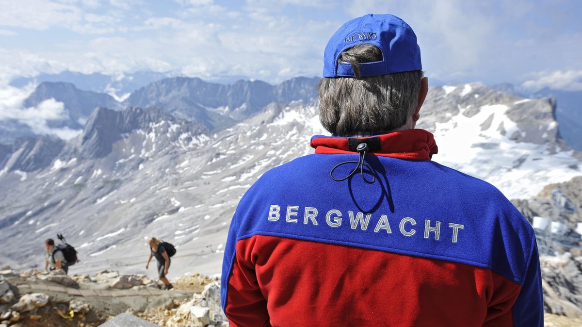 Ein Mitglied der Bergwacht beobachtet Bergsteiger auf ihrem Weg zur Zugspitze. (Symbolbild). 