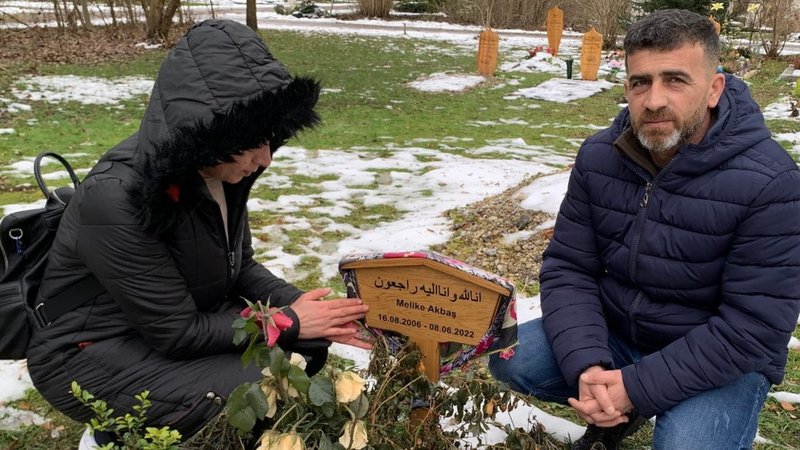 Die Eltern knien am Grab ihrer Tochter die auf der Flucht tödlich verunglückt ist
