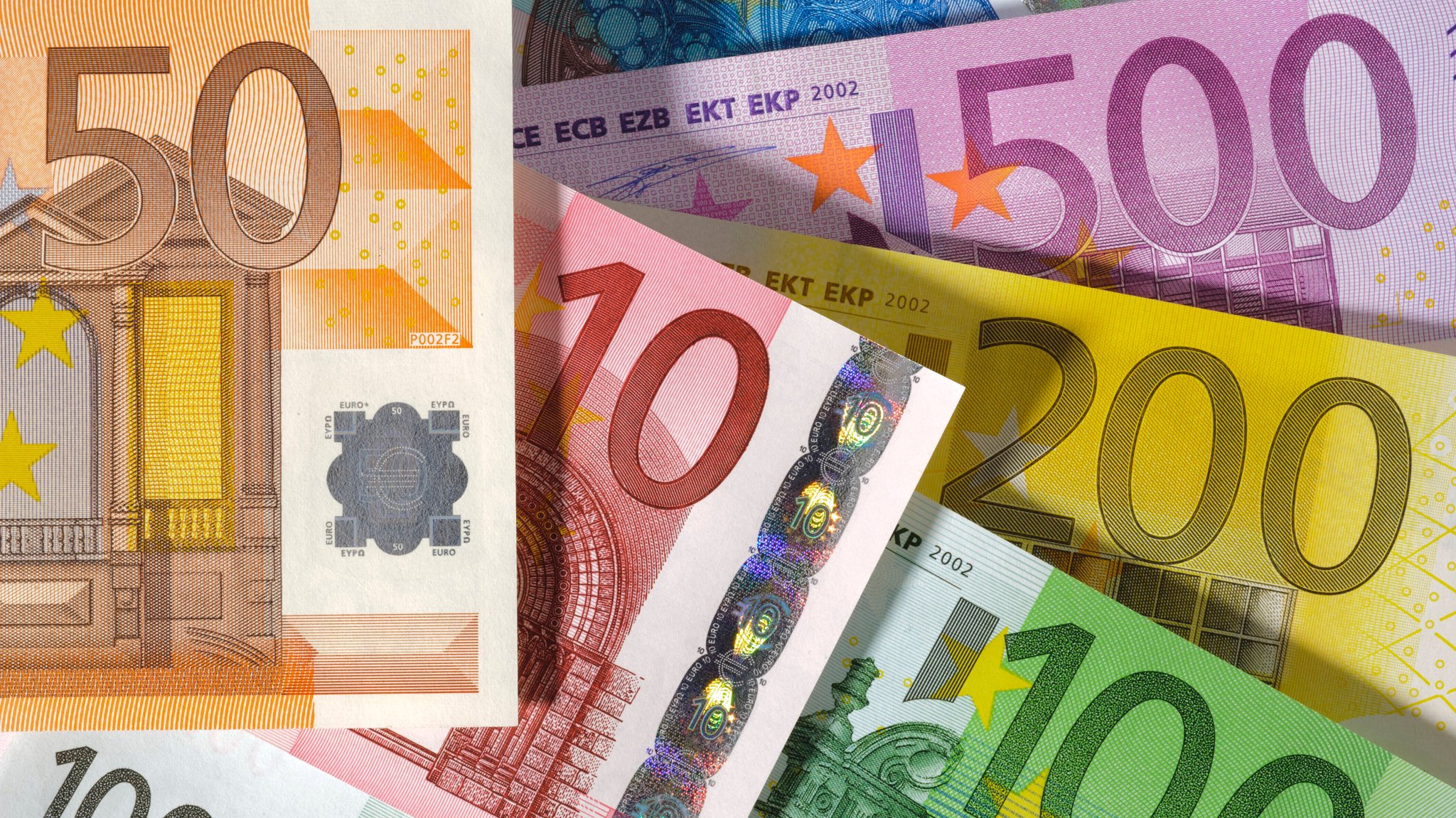 Euroscheine liegen auf einem Tisch. Zu sehen ist ein 50-, 10-, 100-, 200- sowie 500 Euroschein.