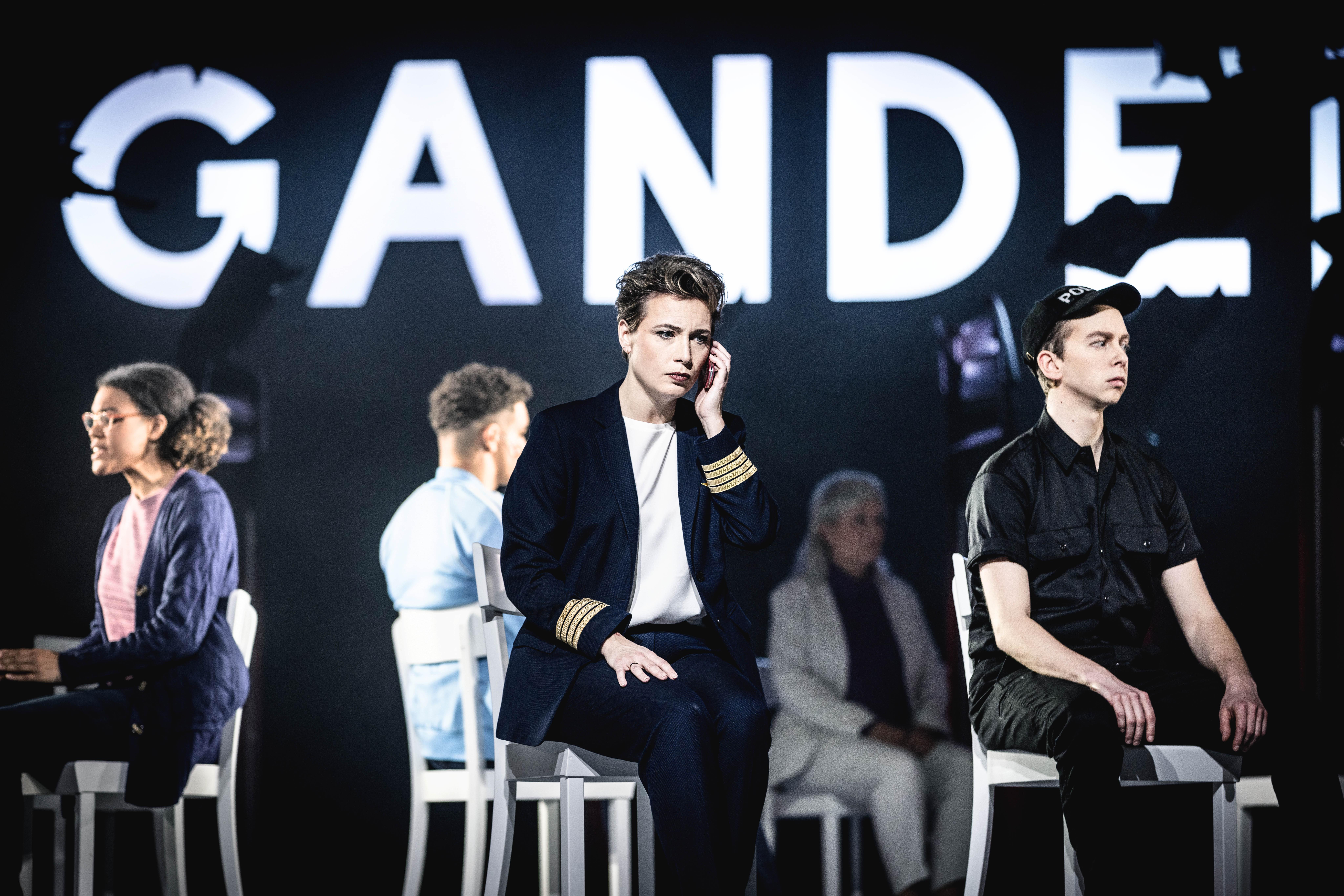 Mitwirkende vor Leuchtschild "Gander"