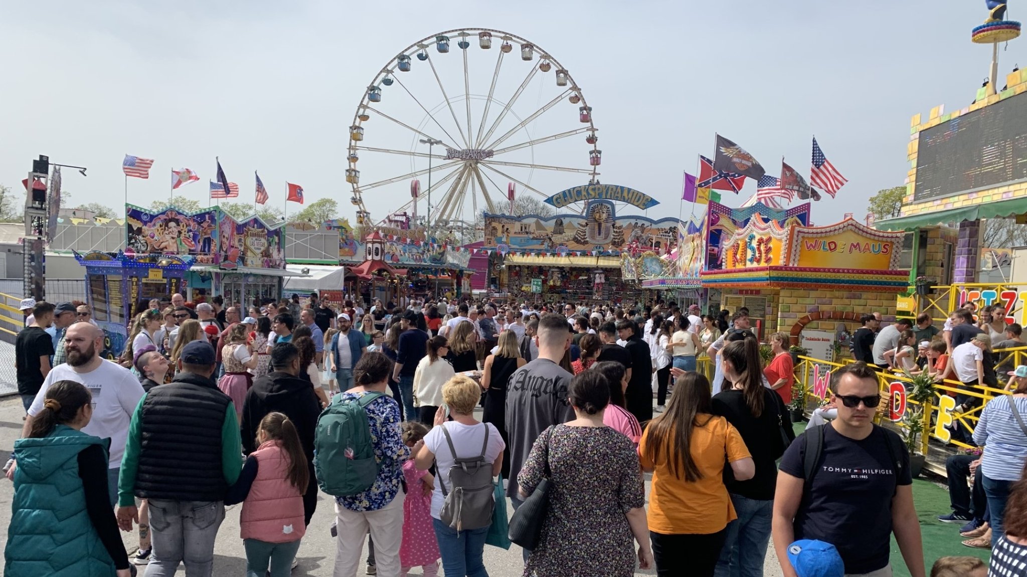 Der Augsburger Frühjahrsplärrer mit vielen Menschen im Vordergrund und einem Riesenrad dahinter.