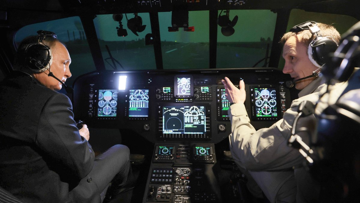 Der russische Präsident sitzt neben einem Piloten im Cockpit