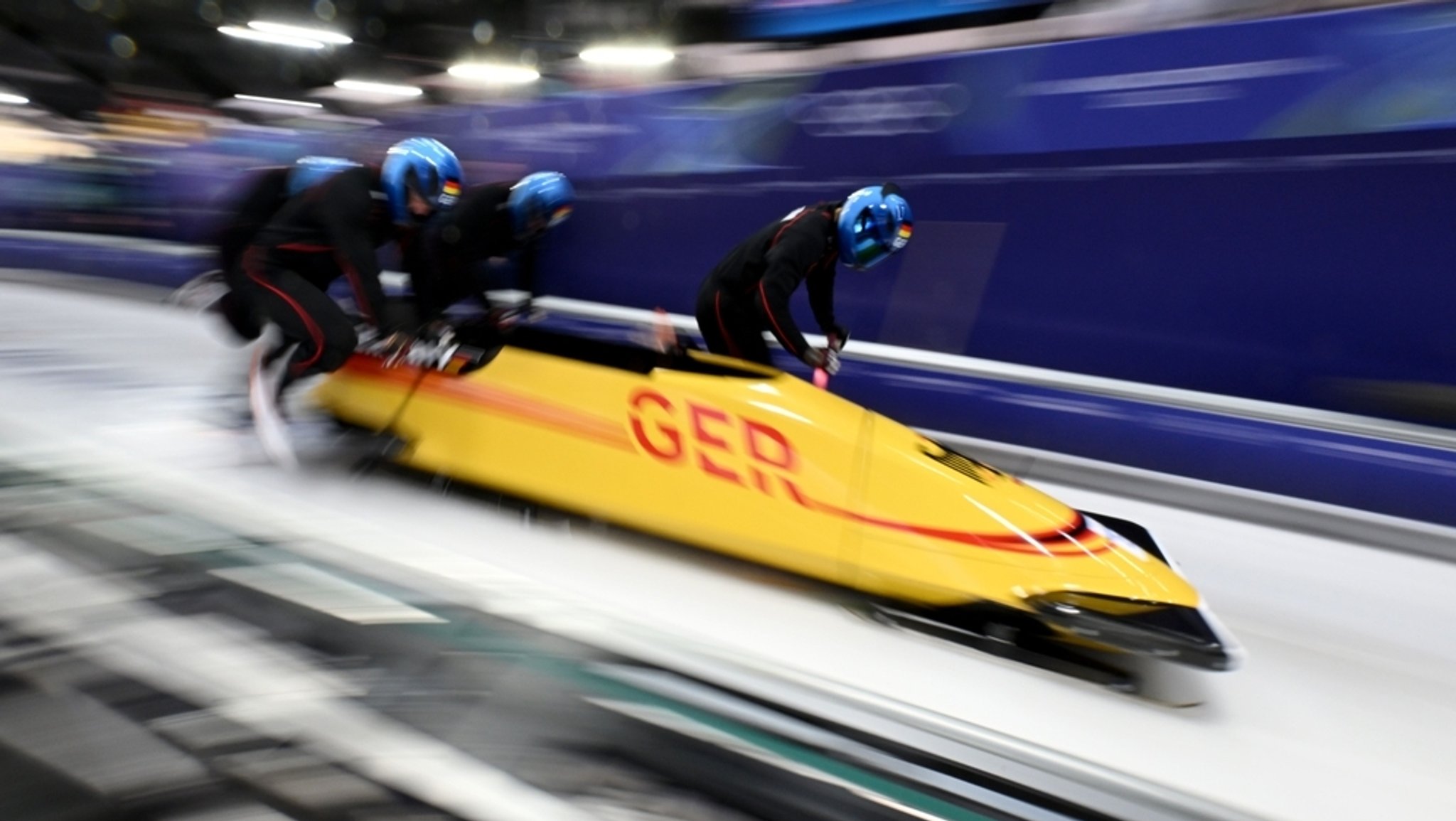 Johannes Lochner und sein Team starten zum Trainingslauf, indem sie den Viererbob auf dem Eiskanal anschieben.
