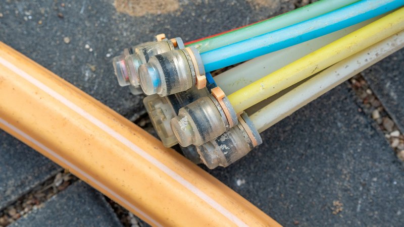 Das Ende einer Glasfaserleitung lieg auf der Straße | Bild: picture alliance / Torsten Sukrow / Das Ende einer Glasfaserleitung lieg auf der Straße