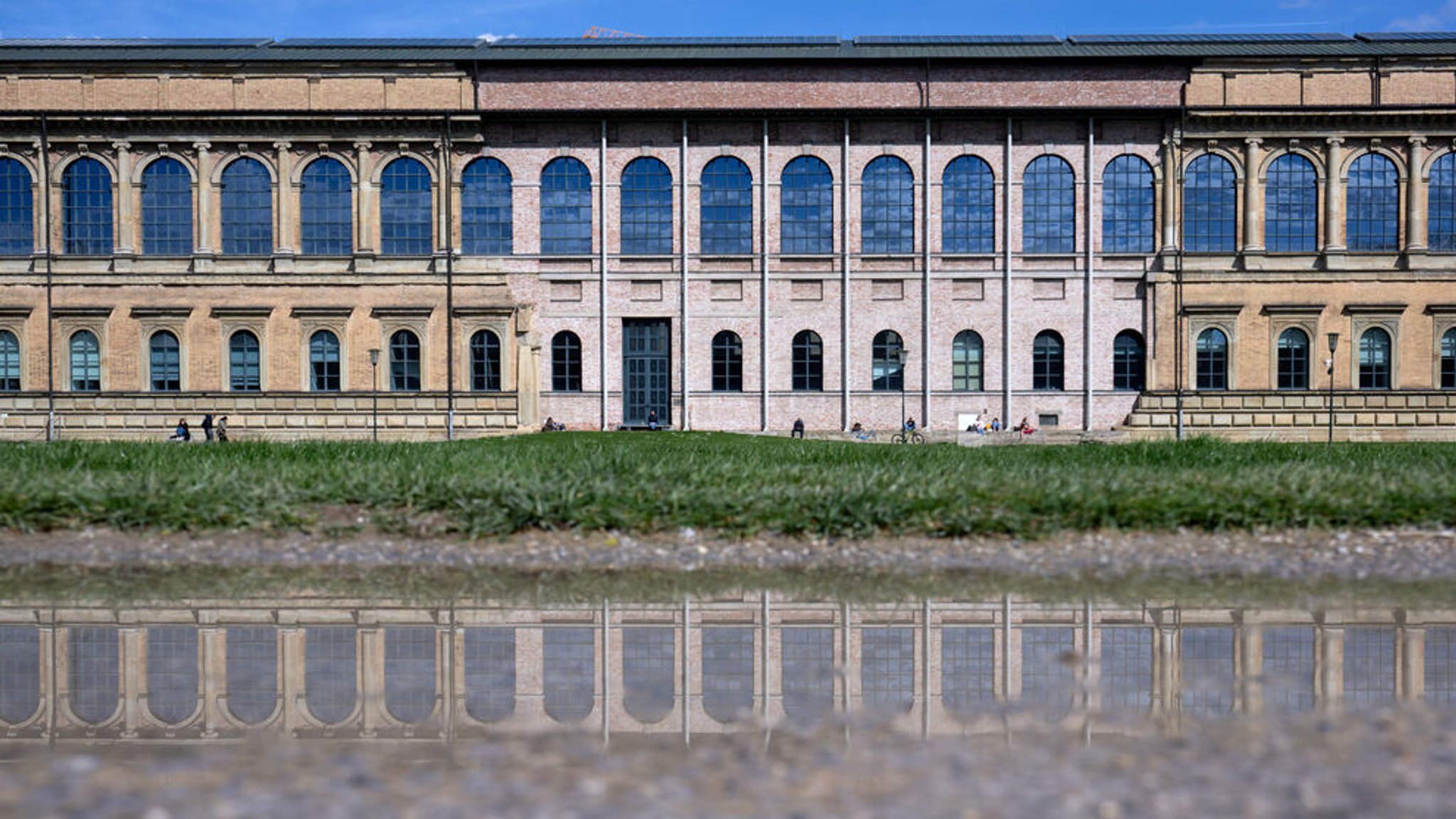 Menschen sitzen vor der alten Pinakothek