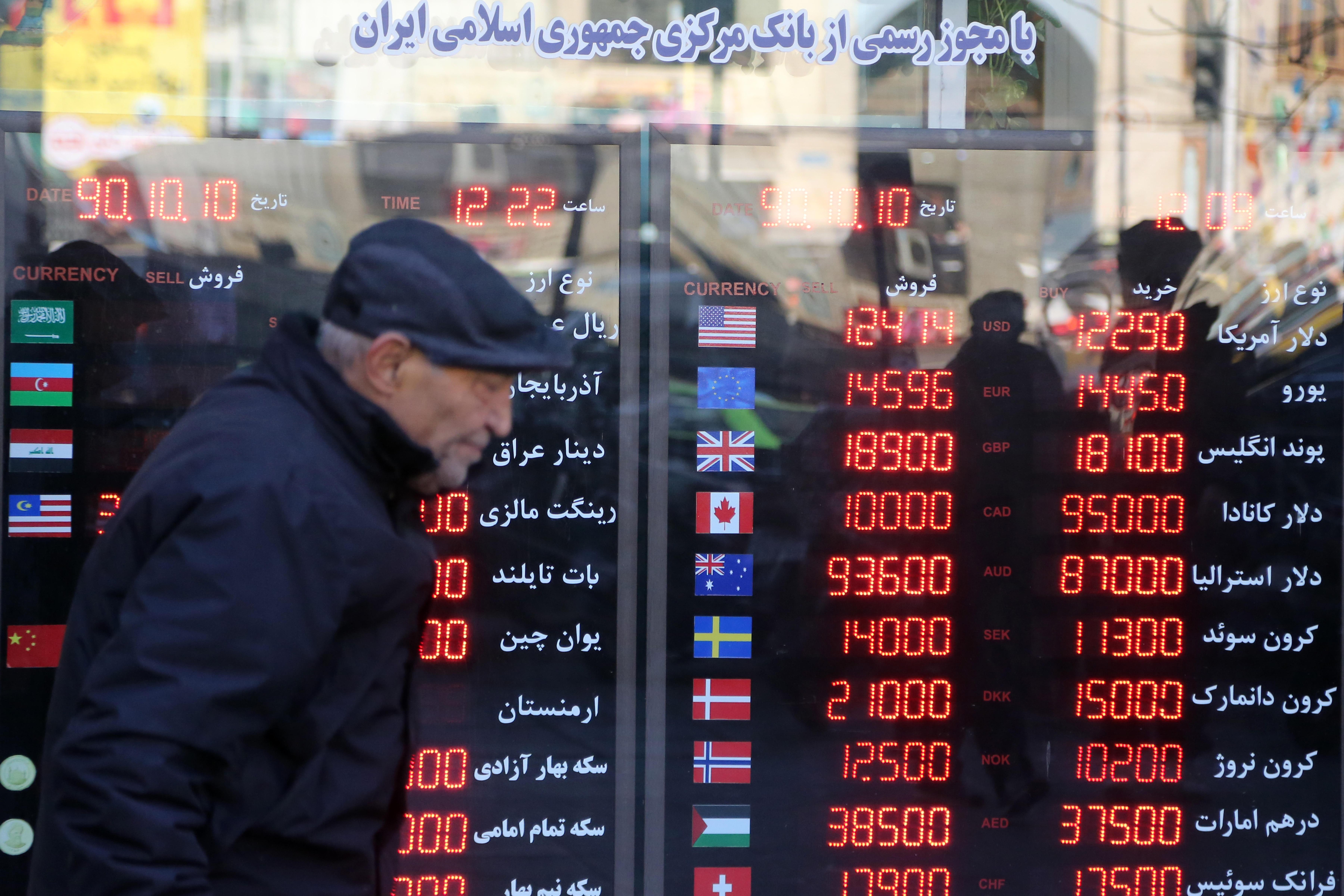 Ein Mann geht in Teheran an Anzeigen für Wechselkurse vorbei