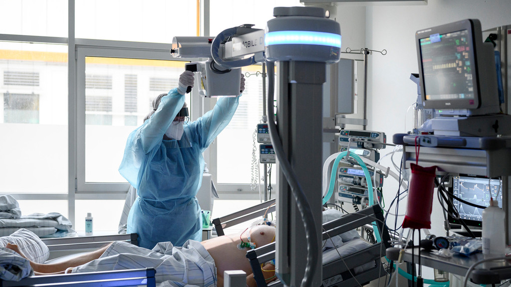 Eine medizinisch technische Radiologieassistentin röntgt die Lunge eines Corona-Patienten auf der Intensivstation (Szene nachgestellt). 